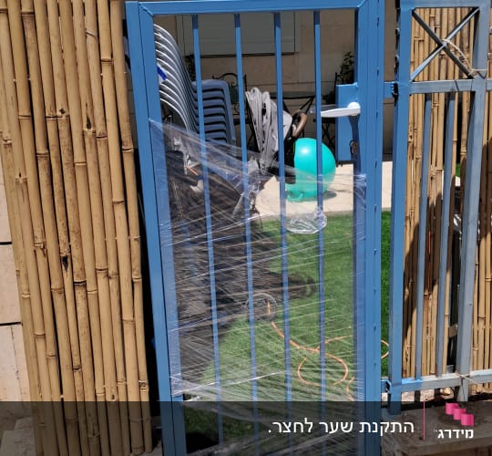 שער מתכת כחול עם עטיפת פלסטיק